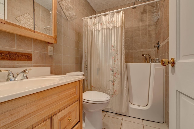 full bathroom with shower / tub combo, tile patterned floors, vanity, a textured ceiling, and tile walls