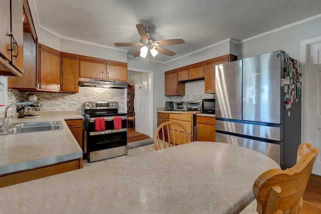 kitchen featuring appliances with stainless steel finishes, light wood-type flooring, ornamental molding, and sink