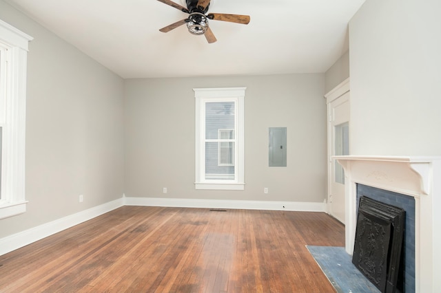 unfurnished living room featuring electric panel, ceiling fan, and dark hardwood / wood-style floors