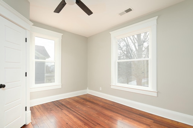 empty room with hardwood / wood-style floors and ceiling fan