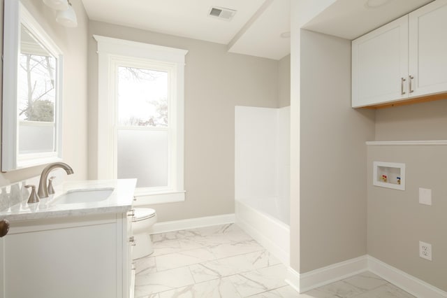 bathroom featuring a bathing tub, vanity, and toilet