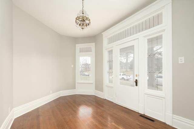 interior space with wood-type flooring and a notable chandelier