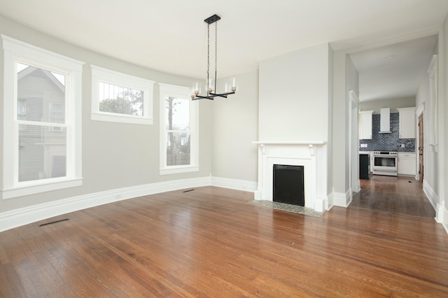 unfurnished living room with dark hardwood / wood-style floors and a notable chandelier