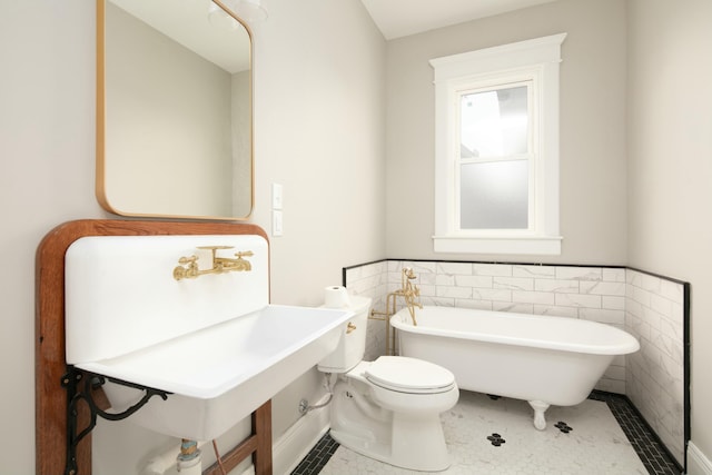 bathroom featuring sink, tile patterned flooring, toilet, a bathtub, and tile walls