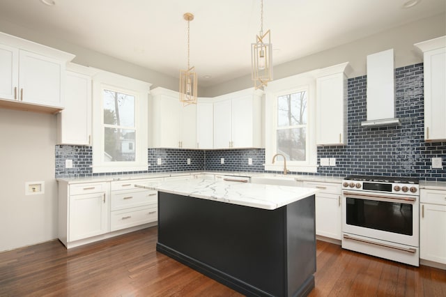 kitchen with high end range, white cabinetry, a kitchen island, and range hood