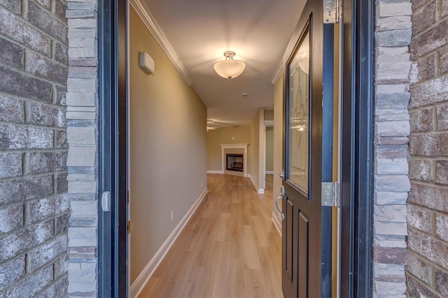 corridor featuring ornamental molding and light hardwood / wood-style flooring