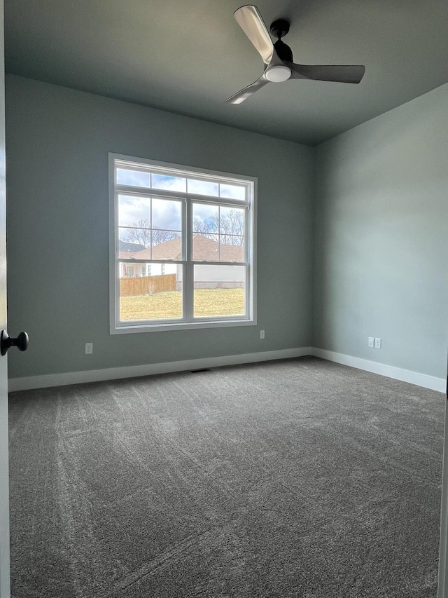 spare room with carpet, baseboards, and ceiling fan