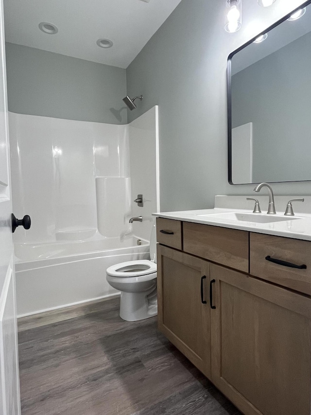 full bathroom with toilet, bathtub / shower combination, wood finished floors, and vanity