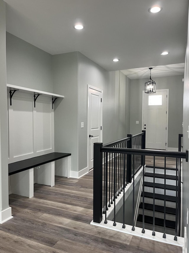 staircase with baseboards, wood finished floors, and recessed lighting