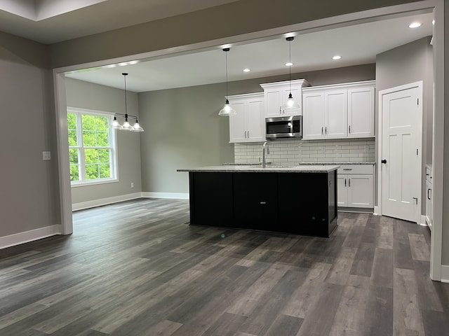 kitchen with dark hardwood / wood-style floors, white cabinetry, and tasteful backsplash