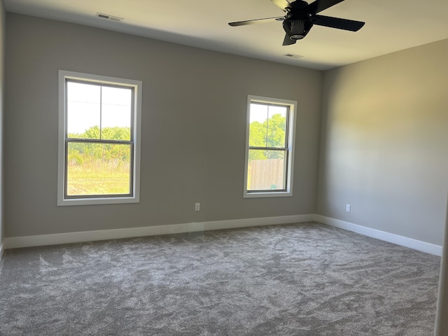 carpeted spare room featuring ceiling fan