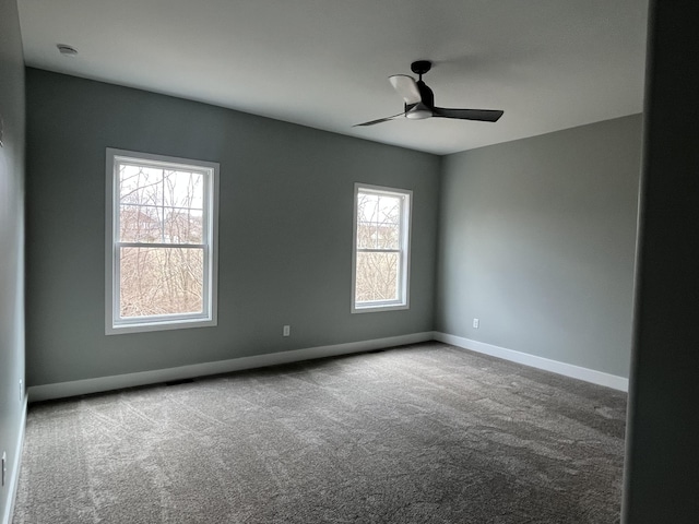 carpeted empty room with a healthy amount of sunlight, baseboards, and a ceiling fan