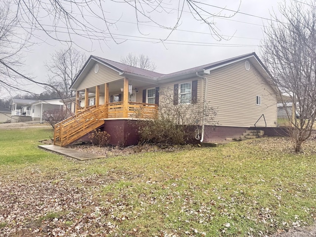 view of side of home with a yard and a porch