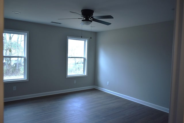 empty room with ceiling fan and dark hardwood / wood-style flooring