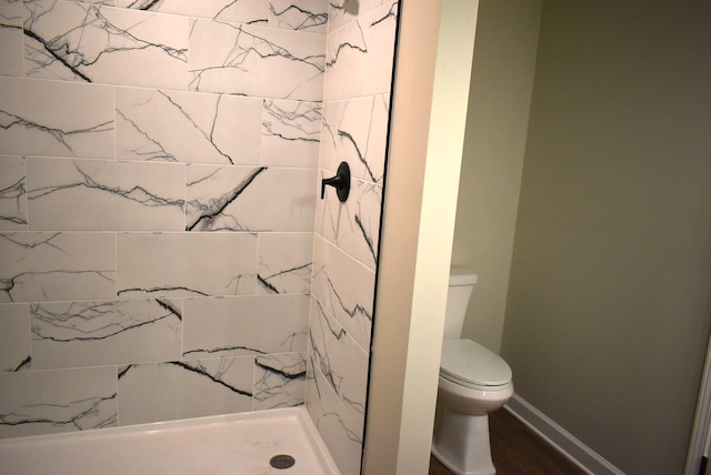 bathroom featuring walk in shower, hardwood / wood-style flooring, and toilet