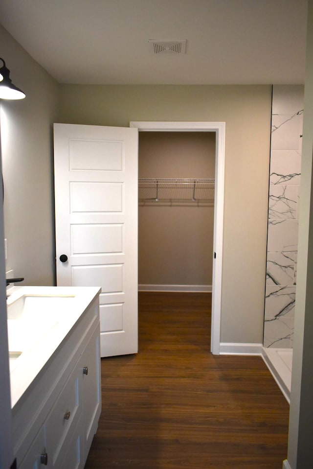 bathroom featuring a shower, vanity, and hardwood / wood-style flooring