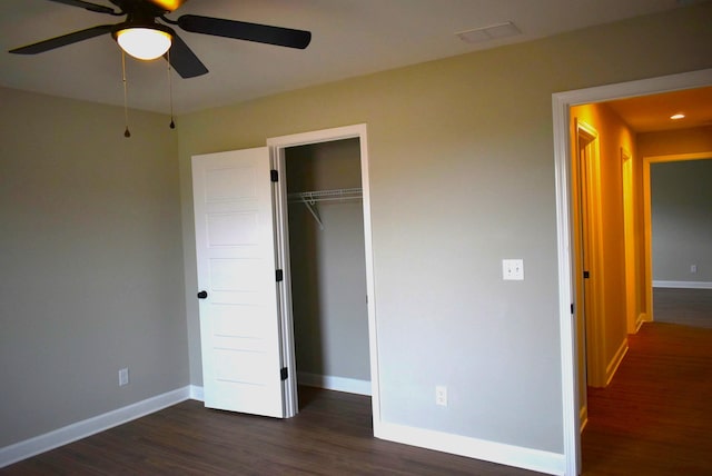 unfurnished bedroom with ceiling fan, dark hardwood / wood-style floors, and a closet