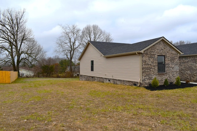 view of side of home with a yard