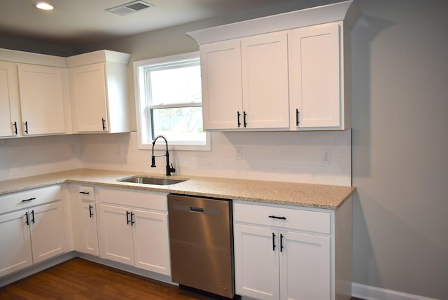 kitchen with dark hardwood / wood-style flooring, tasteful backsplash, stainless steel dishwasher, sink, and white cabinetry