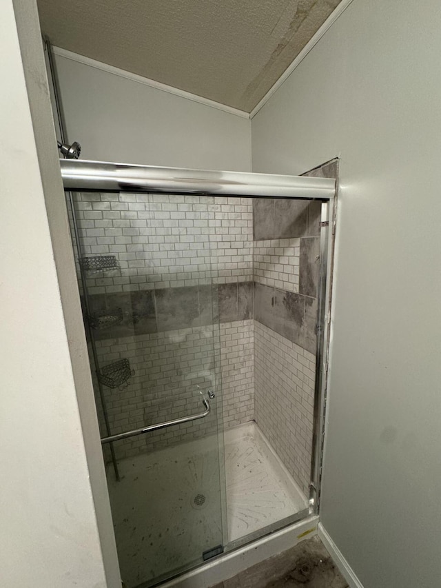 bathroom featuring a shower with shower door and a textured ceiling