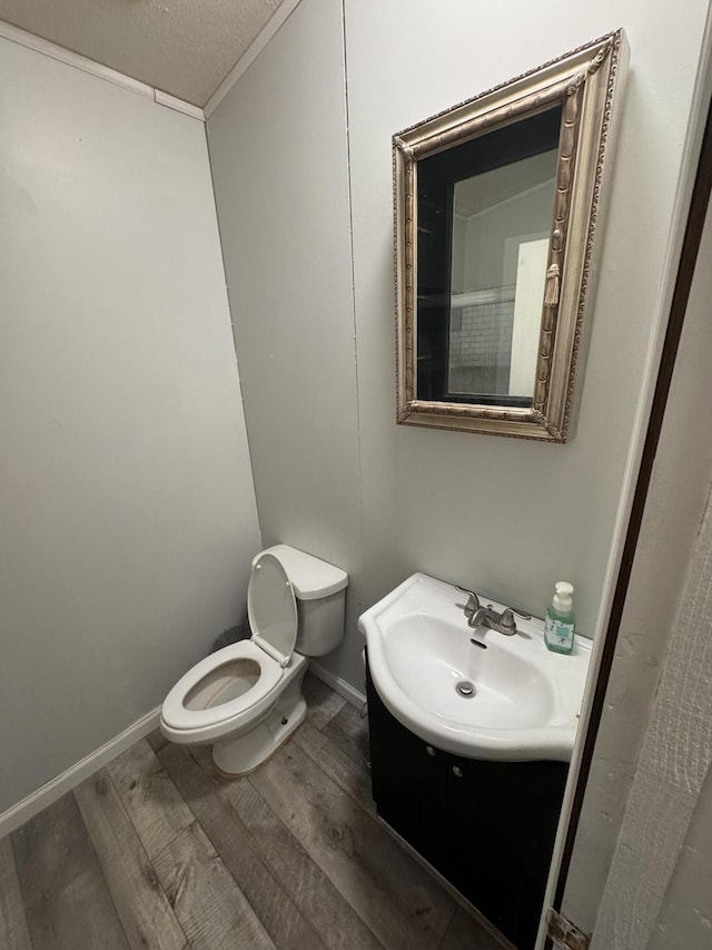 bathroom featuring vanity, toilet, hardwood / wood-style floors, and a textured ceiling