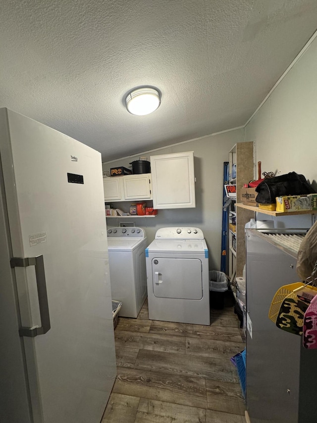 washroom with washer and dryer, dark wood-type flooring, cabinets, and a textured ceiling