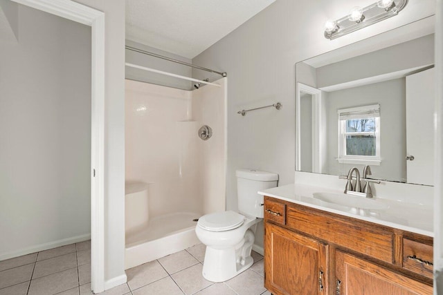 bathroom with tile patterned floors, toilet, vanity, and walk in shower