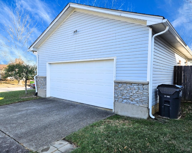 view of home's exterior featuring stone siding, driveway, a garage, and fence