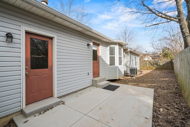 doorway to property featuring a patio area, central AC unit, and fence