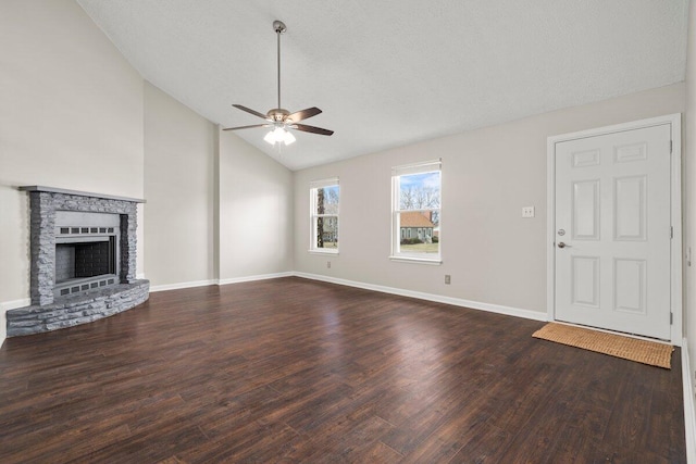 unfurnished living room with a stone fireplace, baseboards, a ceiling fan, and wood finished floors