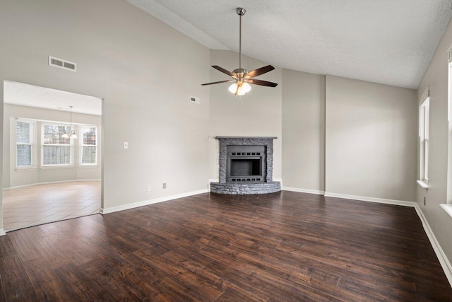 unfurnished living room with wood finished floors, baseboards, visible vents, a fireplace, and ceiling fan