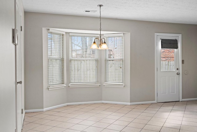 unfurnished dining area with a notable chandelier, plenty of natural light, visible vents, and light tile patterned floors