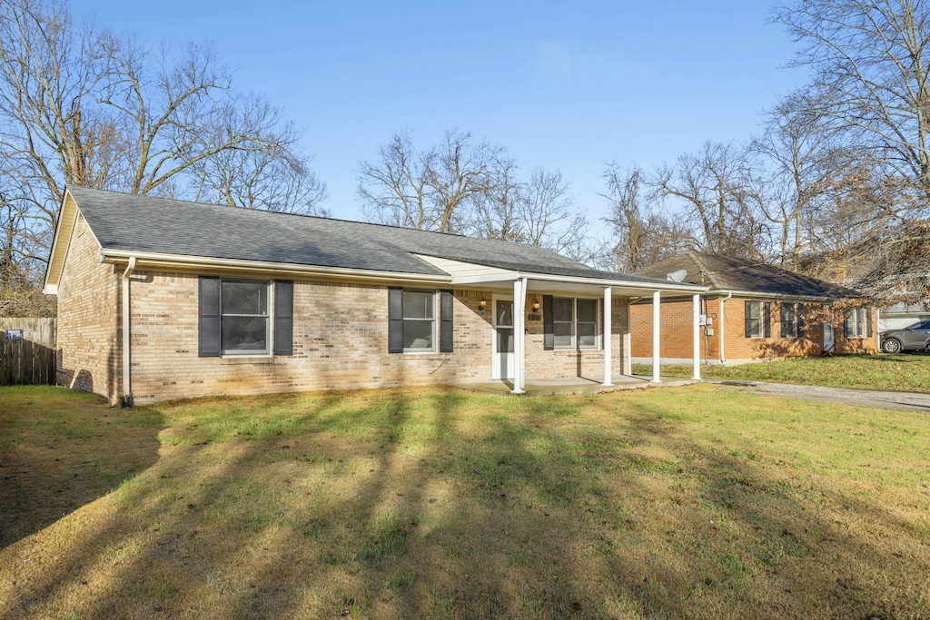 ranch-style home with covered porch and a front yard