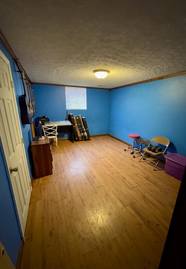 recreation room with hardwood / wood-style floors and a textured ceiling