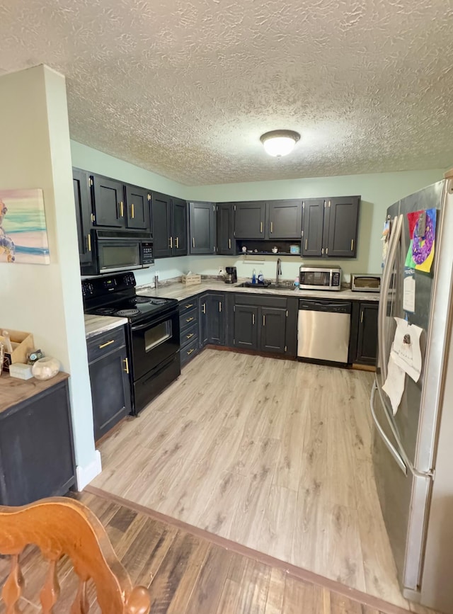 kitchen with sink, a textured ceiling, light wood-type flooring, and black appliances