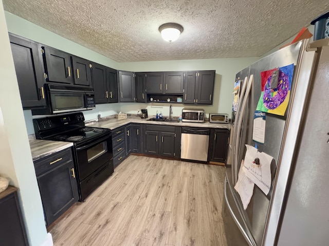 kitchen with sink, black appliances, a textured ceiling, and light hardwood / wood-style floors