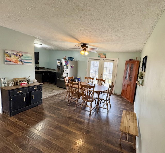 dining space with a textured ceiling, ceiling fan, dark wood-type flooring, and french doors