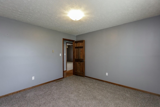 carpeted empty room with a textured ceiling