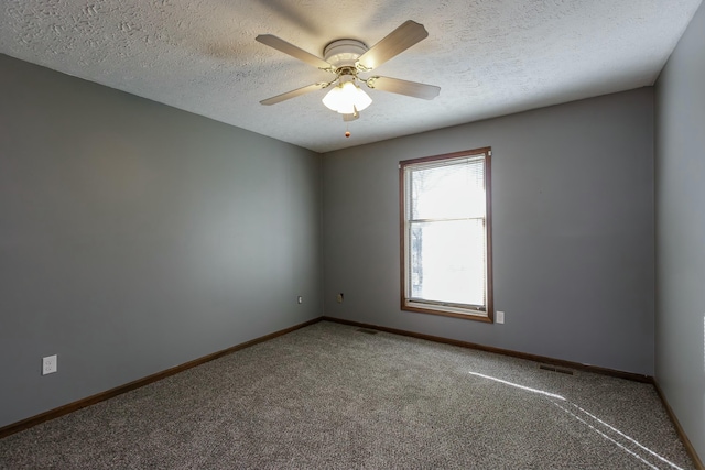 empty room with ceiling fan, carpet, and a textured ceiling