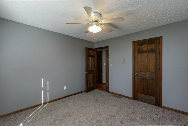 unfurnished bedroom with carpet flooring, ceiling fan, and a textured ceiling