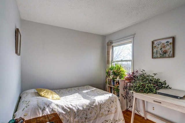 bedroom featuring a textured ceiling and wood-type flooring