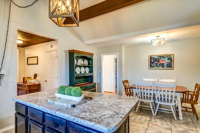 kitchen with decorative light fixtures, light tile patterned floors, lofted ceiling with beams, and a kitchen island