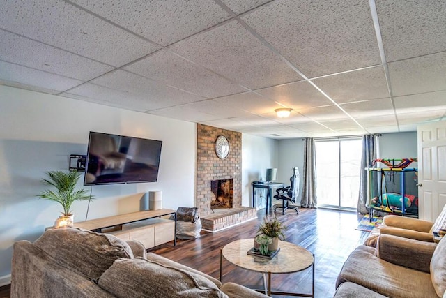 living room with a fireplace, hardwood / wood-style flooring, a paneled ceiling, and floor to ceiling windows