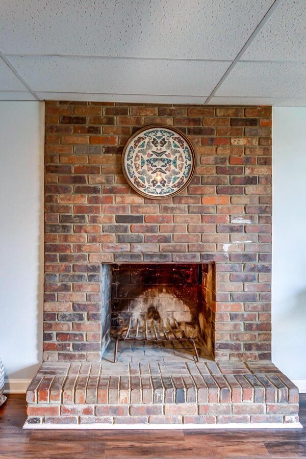 interior details with a paneled ceiling, a fireplace, and hardwood / wood-style floors