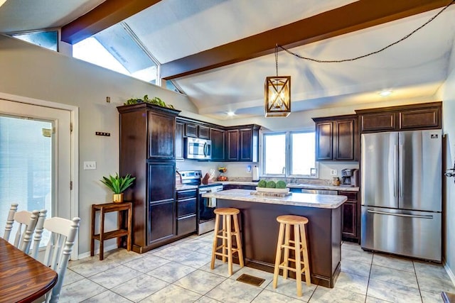 kitchen featuring dark brown cabinets, decorative light fixtures, lofted ceiling with beams, a center island, and stainless steel appliances