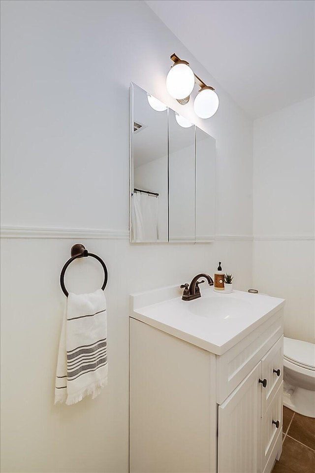 bathroom featuring tile patterned floors, vanity, and toilet