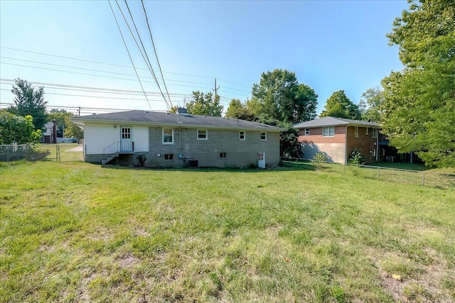 back of property with a lawn and central air condition unit