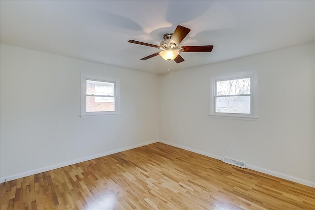 spare room featuring ceiling fan, a healthy amount of sunlight, and light hardwood / wood-style flooring