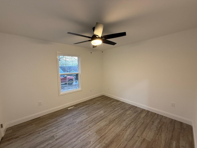 unfurnished room featuring ceiling fan and dark wood-type flooring