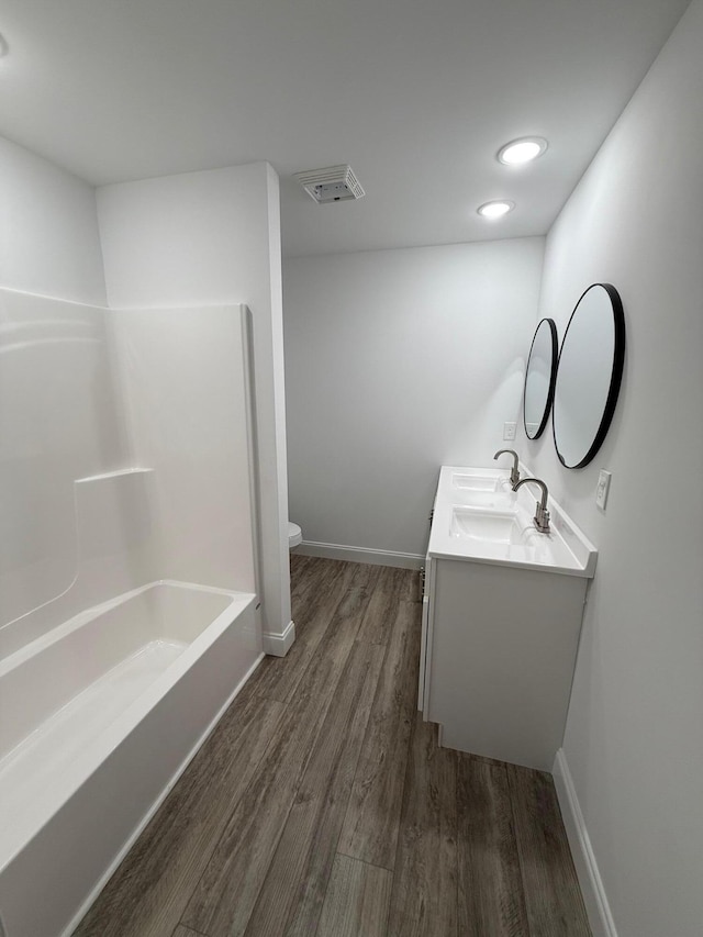 bathroom featuring toilet, vanity, and hardwood / wood-style flooring